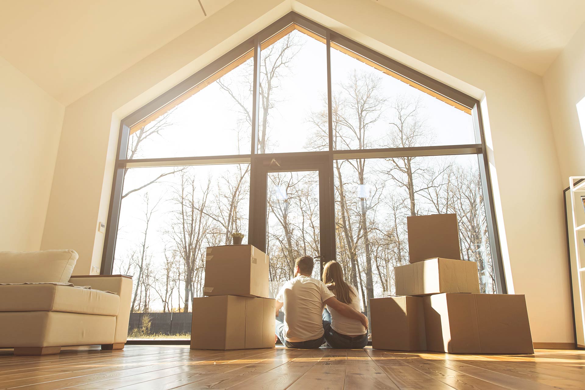 Ein Bild von einem Paar, das vor einem Fenster sitzt, mit Karton um sie herum