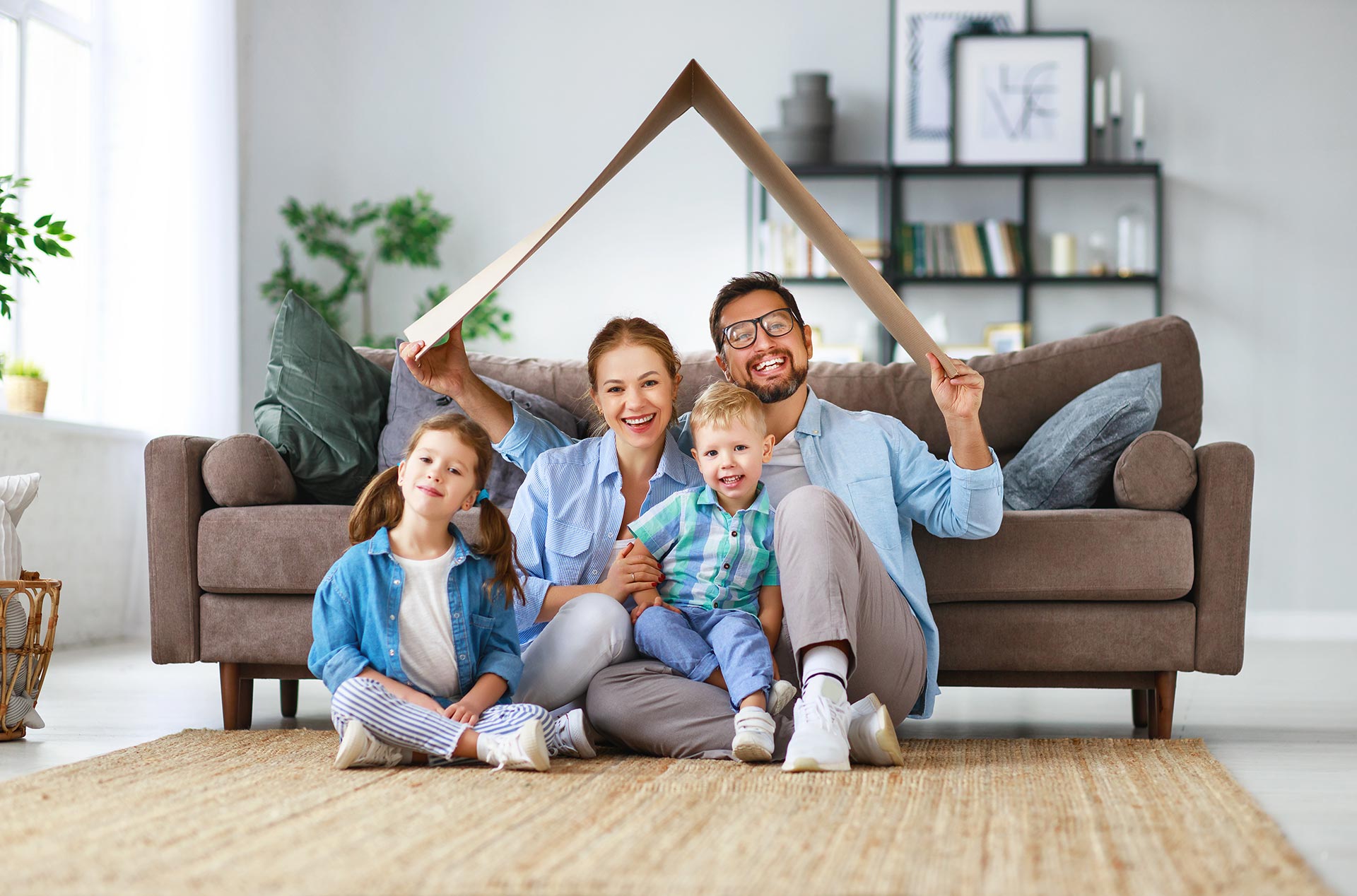 Eine Familie unter einem Dach aus Karton